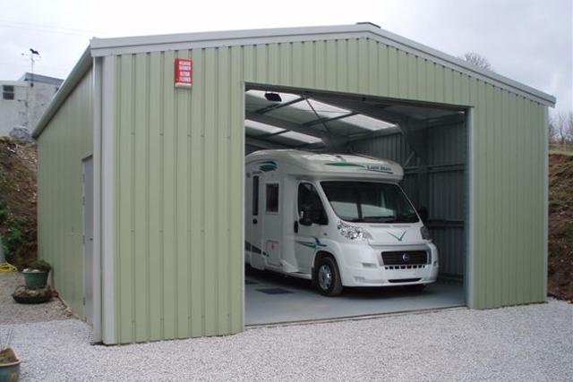 A green building housing a large white motorhome